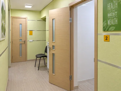 Светлый коридор стоматологической клиники с дверями в лечебные кабинеты